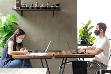 New normal people coworking working inside wearing protective mask for coronavirus spread.