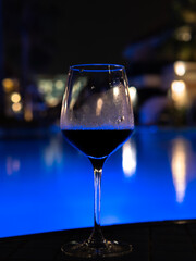 Sharp wine glass with the pool and blurred hotel lights background