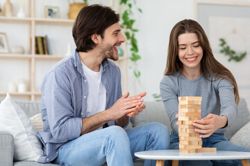Couple playing wooden blocks at living room at home