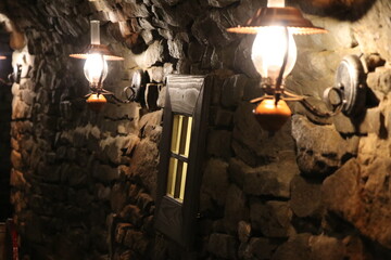 Lampy naftowe oświetlające stary mur - obrazy, fototapety, plakaty