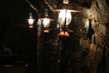 Lampy oświetlające stary kamienny mur - obrazy, fototapety, plakaty