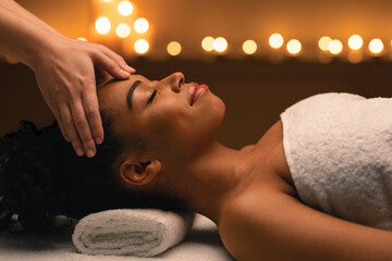 Side view of african girl getting healing head massage