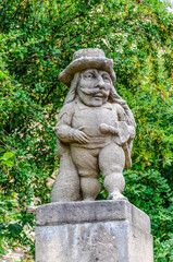 Fototapeta na wymiar Statue of a male dwarf (carved by workshop of baroque sculptor Matthias Bernard Braun) in the garden of the castle, Nove Mesto nad Metuji, Czech republic