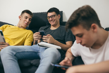 teenager boys using mobile phones at home
