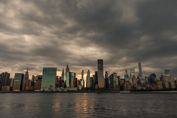 Fototapeta na wymiar Dark and Ominous Sky with the Midtown Manhattan Skyline during a Sunset along the East River in New York City