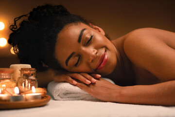 Obraz na płótnie Canvas Closeup of joyful black lady sleeping at spa salon