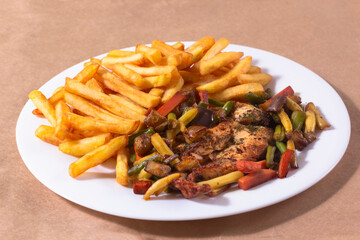 A nice plate of roasted chicken, seasoned with herbs, pepper, salt, oregano, and garlic. Also accompanied by vegetables fried on olive oil.
Accompanied by French fries on a white plate.
