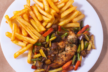A nice plate of roasted chicken, seasoned with herbs, pepper, salt, oregano, and garlic. Also accompanied by vegetables fried on olive oil.
Accompanied by French fries on a white plate.