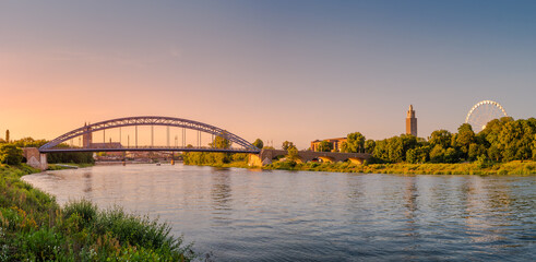 Panoramic view over colorful sunset in front of cathedral, new stars bridge, old bridge and city observation Ferris wheel in Magdeburg, Germany