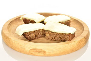 Slices of black cereal bread with butter on a white background.