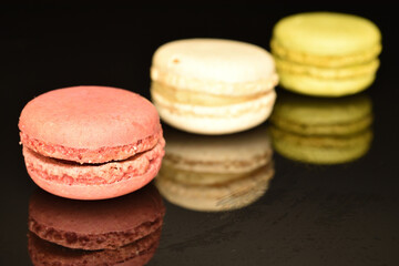 Tasty multi-colored, sweet macaroons, on a black background.