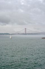 25th of April Suspension Bridge over the Tagus river in Lisbon, Portugal Havy rainy clouds and fog at Ponte 25 de Abril, Lisboa, Portugal