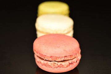 Tasty multi-colored, sweet macaroons, on a black background.