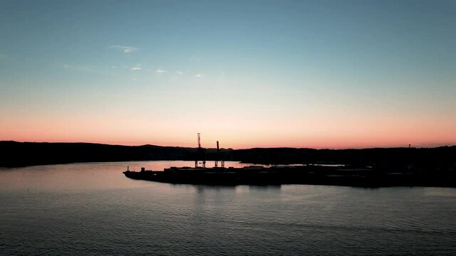 Cranes from Larvik cargo harbor with a beautiful blue and orange sunset in the background