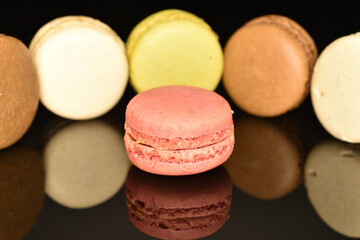 Tasty multi-colored, sweet macaroons, on a black background.