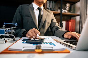 Businesswomen hands working with finances about cost and calculator and laptop with tablet, smartphone at office in morning light