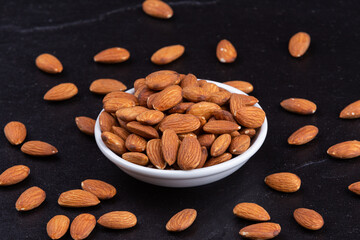 Dried almond on black stone background