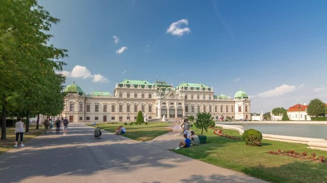 Belvedere palace with beautiful floral garden timelapse hyperlapse, Vienna Austria. Blue sky with clouds on sunny day. Green lawn and historic buildings