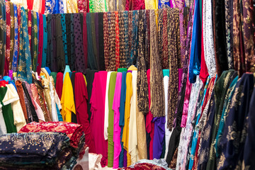clothes in shop, Rolls of fabric and textiles for sale stacked on shelves in shop, View of cloth rolls of different colors and patterns on shelves in fabric store