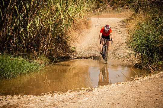 A man riding a gravel bike through a river. Malaga, Spain.