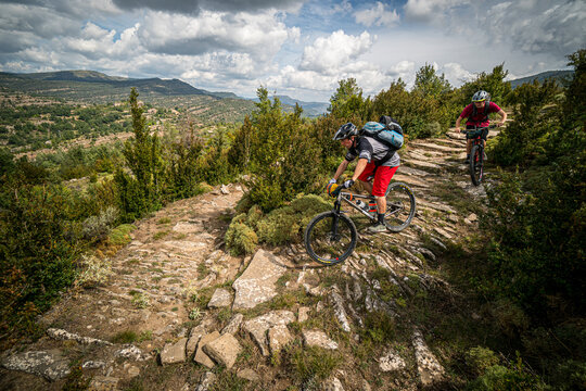 Two mountain bikers on a rocky path in the low Pyrenees. Huesca, Spain.