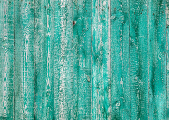 Fototapeta na wymiar Wooden boards on an old green fence as an abstract background.