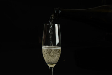 A dark image of champagne being poured into a glass