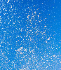 Splashing water from a fountain on a background of blue sky