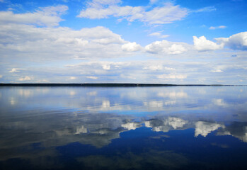 Clouds on a blue sky with reflection in water