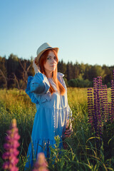 Redhaired girl in a hat looks directly at the camera