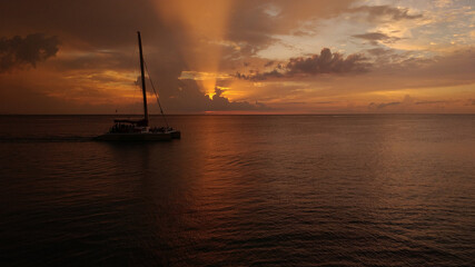 A calm sunset over the ocean in Jamaica with a boat