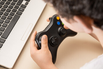 Boy playing game on computer with wireless controller