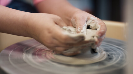 child doing pottery