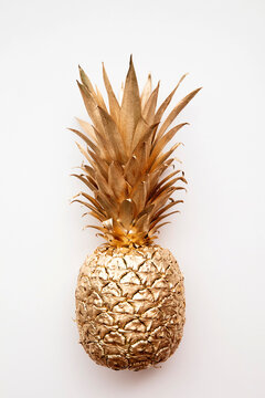 trendy tropical gold pineapple on a plain white background top view