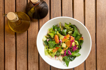 Ease to do avocado and orange salad with greens. Conditioned with olive oil and vinegar. Top view