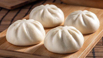 Fototapeta na wymiar Delicious baozi, Chinese steamed meat bun is ready to eat on serving plate and steamer, close up, copy space product design concept.
