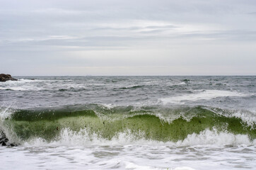 Fototapeta na wymiar Ocean waves with foam on a shore of sand beach