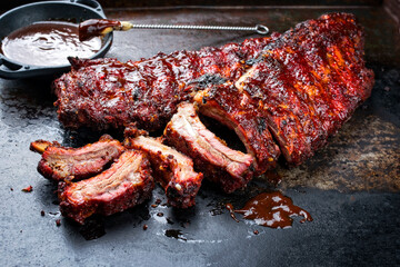 Barbecue pork spare loin ribs St Louis cut with hot honey chili marinade burnt as closeup on an old...