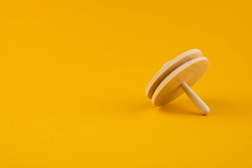 Children's wooden toy spinning top close up with copy space. Concept of educational games