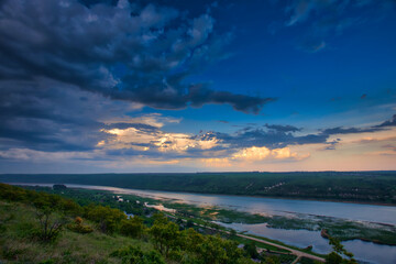 Fototapeta premium river in green landscape and dramatic clouds with blue sky