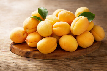 Naklejka na ściany i meble fresh ripe apricots on a wooden table