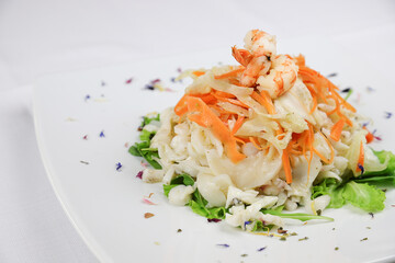 Seafood salad served in white plate closeup. Appetizer on restaurant table. Mediterranean cuisine recipe. Luxury sea food dinner
