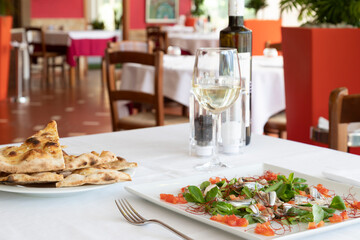 Anchovy dish with tomato and rocket salad and white pizza