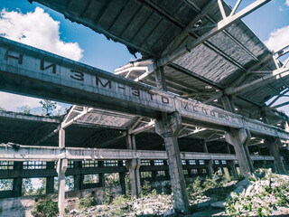 Obraz premium Soviet ruins of the plant. The abandoned building was overgrown with greenery and collapsed.