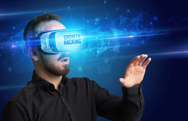 Businessman looking through Virtual Reality glasses with GROWTH HACKING inscription, cyber security concept