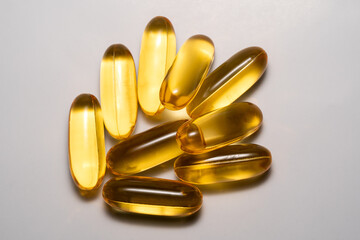 Golden fish oil tablets on a white background