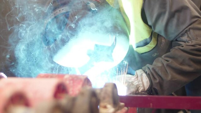 worker welding steel with mig welder machine slow motion
