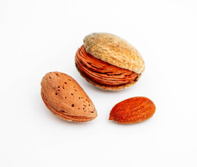 A pile of wild peeled almond nuts and kernels, closeup, isolated on white background.