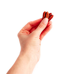 Three raw pecan nuts, hold in a female hand, isolated on white background.