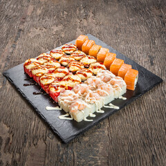 Japanese cuisine. Seafood, vegetables and meat. Sushi and rolls big set isolation on a wooden table background
